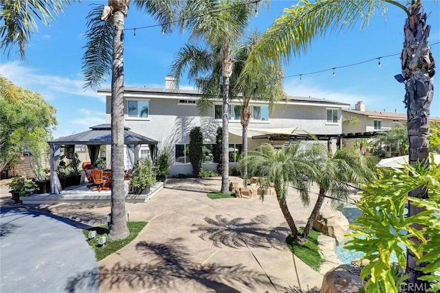 1610 Via Roma Cir, Corona, CA 92881 - view of front of property with a gazebo, stucco siding, a patio, and solar panels