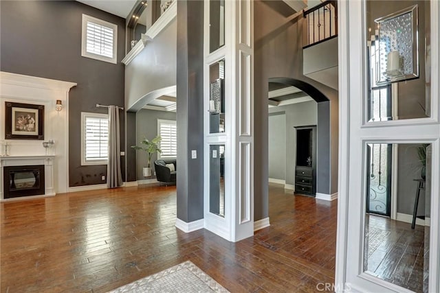 1610 Via Roma Cir, Corona, CA 92881 - entrance foyer with a glass covered fireplace, a towering ceiling, arched walkways, and dark wood finished floors