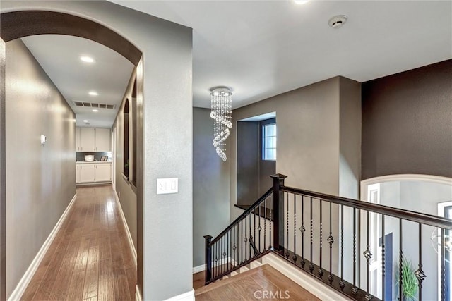 1610 Via Roma Cir, Corona, CA 92881 - hallway with visible vents, an upstairs landing, wood-type flooring, arched walkways, and baseboards