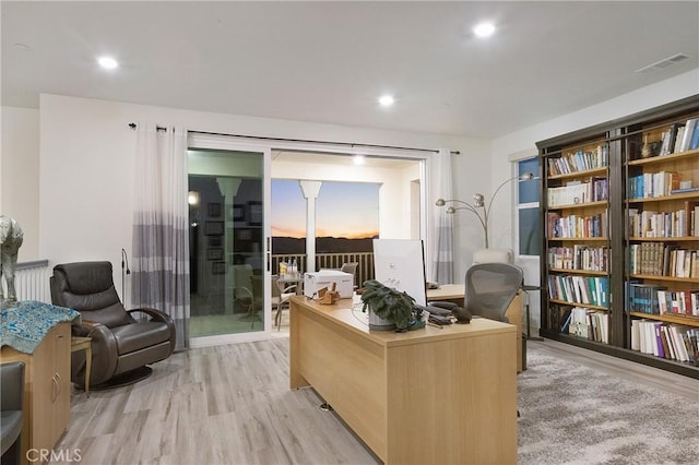 home office featuring light wood-style flooring and visible vents