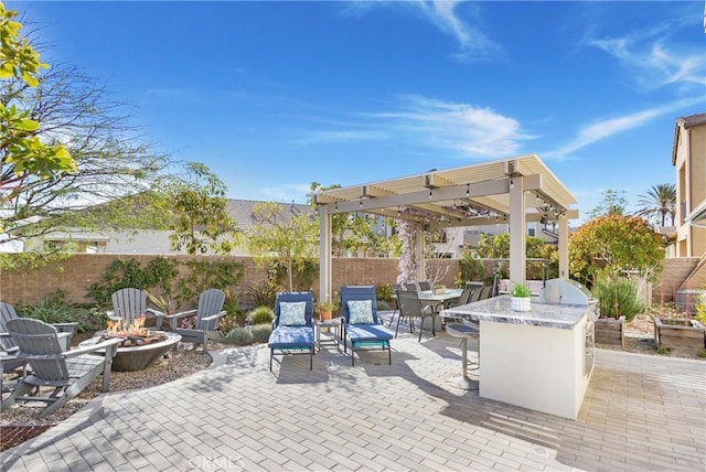 view of patio / terrace with fence, a fire pit, and outdoor dry bar