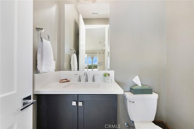 bathroom with visible vents, toilet, and vanity