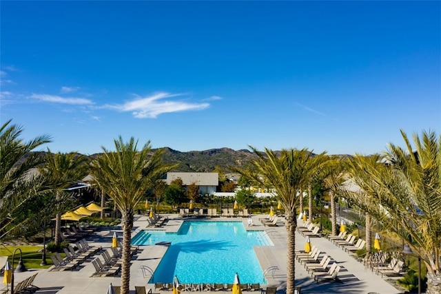 community pool featuring a mountain view and a patio area