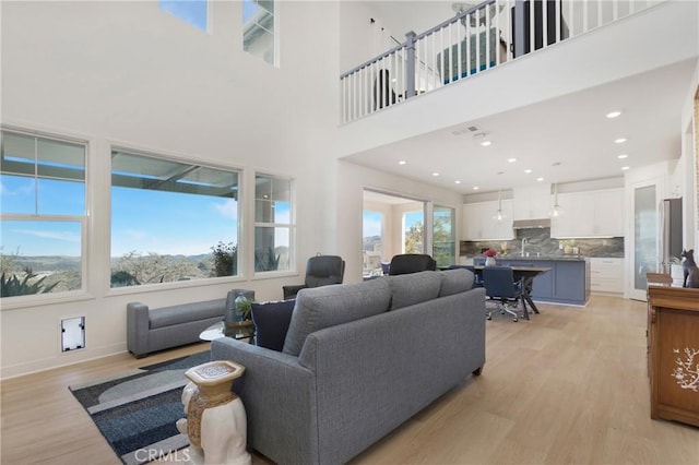 living area featuring a high ceiling and light wood finished floors