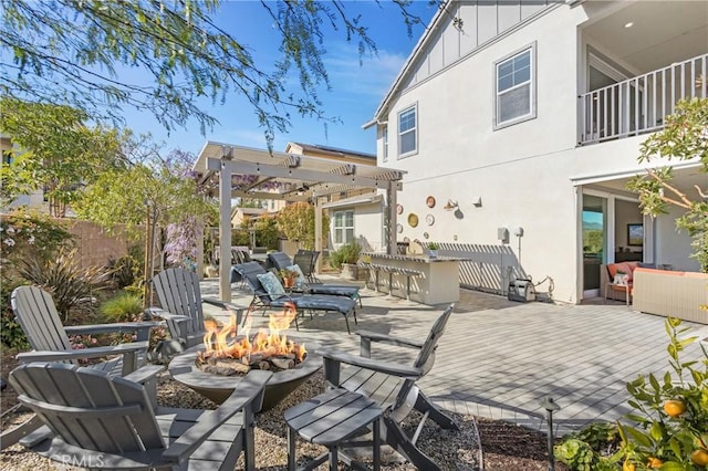 view of patio / terrace featuring a fire pit, a pergola, fence, outdoor dry bar, and a deck