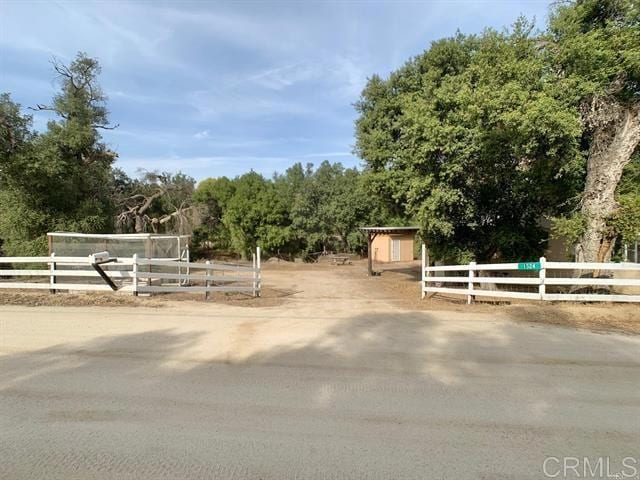view of yard with a rural view, an outbuilding, and fence