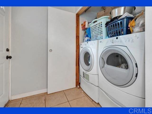 clothes washing area with tile patterned flooring, laundry area, and washing machine and dryer