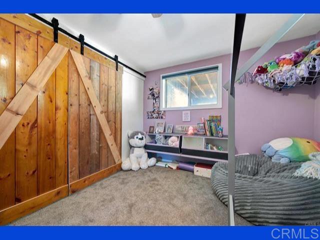 carpeted bedroom with a barn door