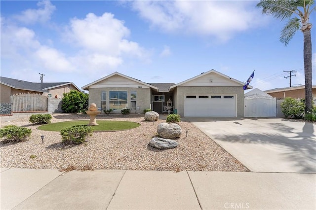 ranch-style house featuring a gate, fence, driveway, and an attached garage