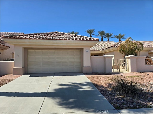 mediterranean / spanish-style house with stucco siding, an attached garage, and fence