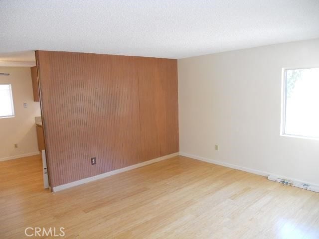 unfurnished room featuring light wood-style flooring and baseboards
