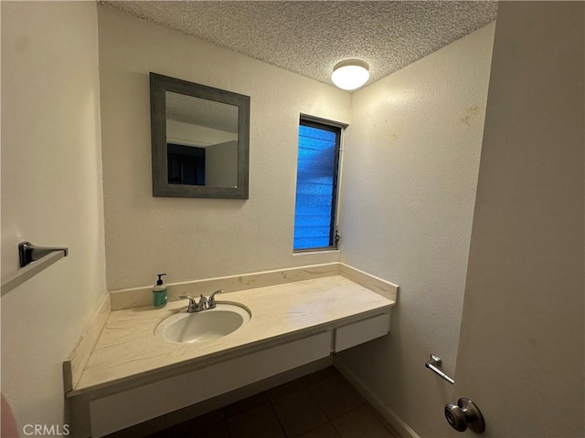 bathroom with vanity, a textured wall, tile patterned flooring, and a textured ceiling
