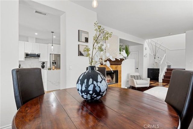 11891 Ramsdell Ct, San Diego, CA 92131 - dining area with stairs, a tile fireplace, and visible vents