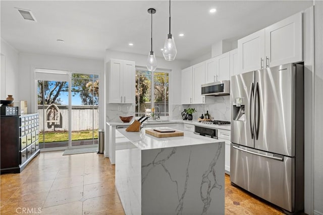 11891 Ramsdell Ct, San Diego, CA 92131 - kitchen with appliances with stainless steel finishes, tasteful backsplash, light stone counters, recessed lighting, and white cabinetry