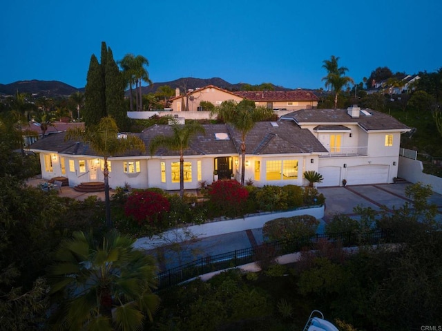 view of front of house featuring a balcony, fence, a garage, concrete driveway, and a mountain view