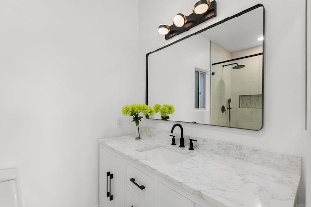 bathroom with vanity, toilet, and a shower stall