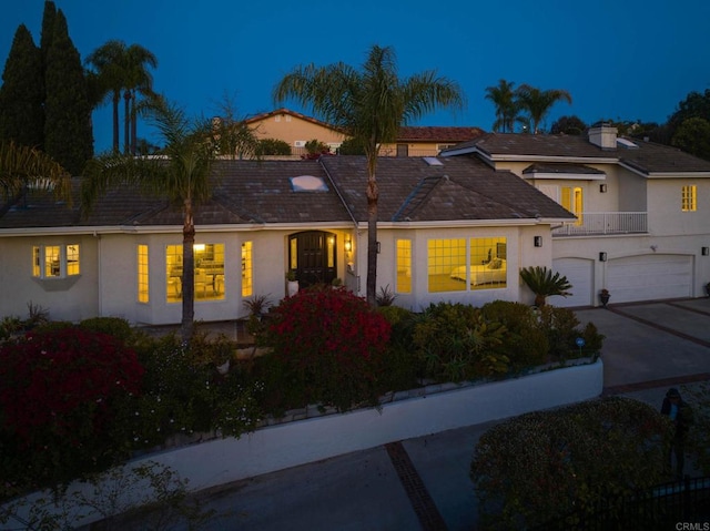 view of front facade with driveway, a garage, and stucco siding
