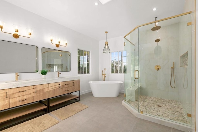 full bathroom with double vanity, a sink, a freestanding tub, and a stall shower