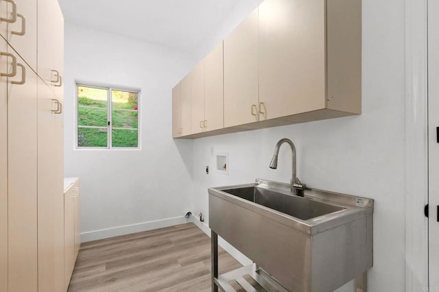 laundry room featuring gas dryer hookup, washer hookup, a sink, light wood-style floors, and cabinet space