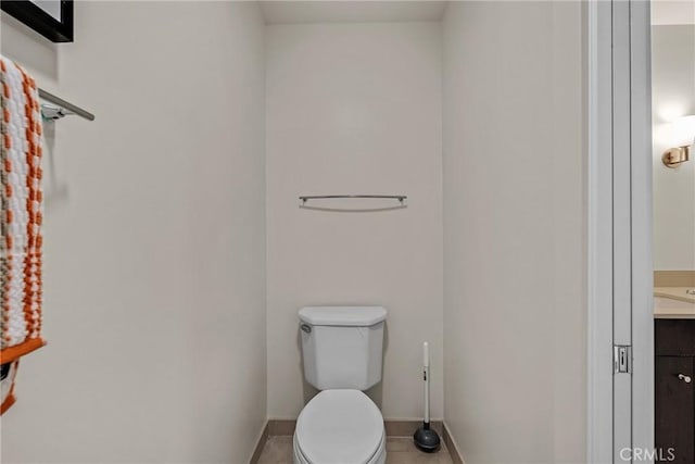 bathroom featuring baseboards, tile patterned floors, vanity, and toilet