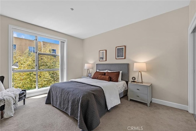 bedroom featuring light colored carpet and baseboards