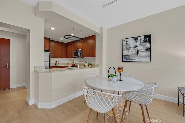 dining room with light wood-type flooring, baseboards, and recessed lighting