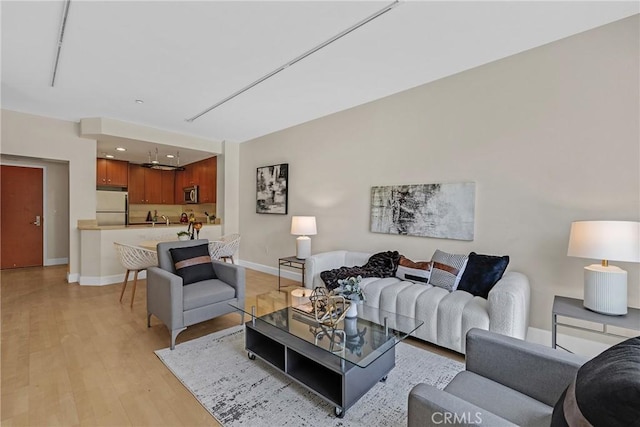 living room with light wood-type flooring and baseboards