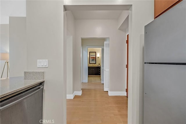hallway with light wood-style flooring and baseboards