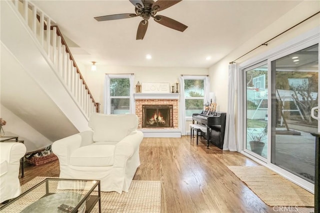 living room featuring recessed lighting, stairway, a fireplace, light wood finished floors, and ceiling fan