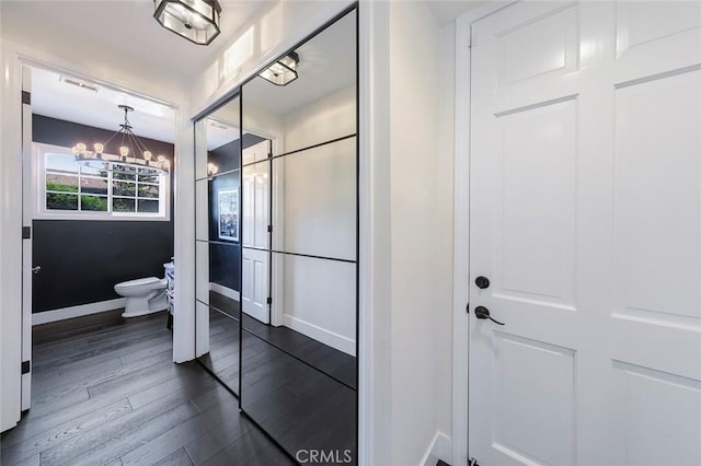 bathroom featuring baseboards, an inviting chandelier, toilet, visible vents, and wood finished floors