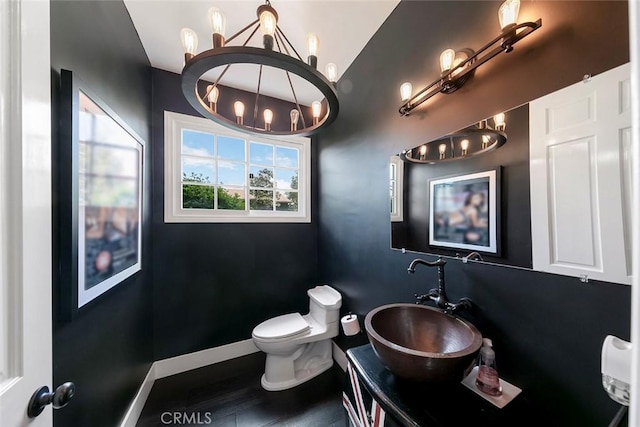 bathroom with vanity, a notable chandelier, baseboards, and toilet