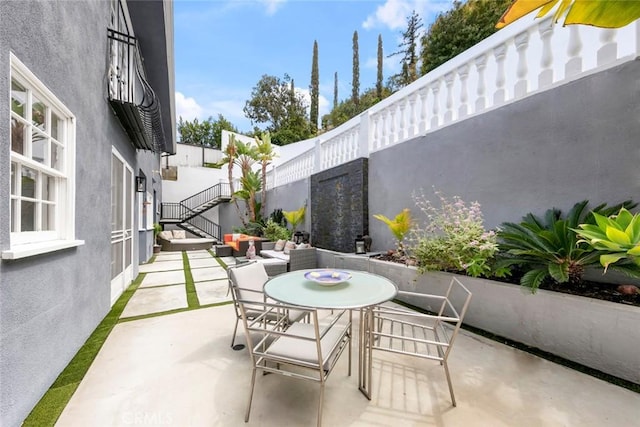 view of patio featuring outdoor dining space and stairs