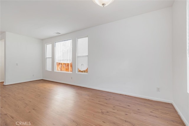 spare room with light wood-style floors and baseboards