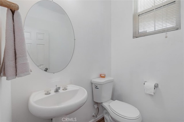 half bathroom featuring toilet and a sink