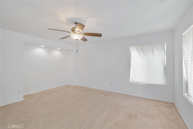 empty room featuring baseboards, a ceiling fan, and carpet floors