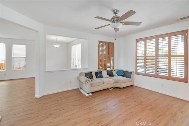 sitting room featuring light wood finished floors, visible vents, baseboards, and ceiling fan