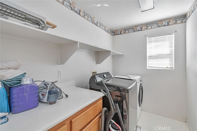 washroom featuring washer and clothes dryer, laundry area, and baseboards