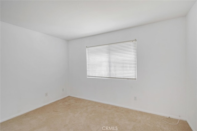 empty room with light carpet and baseboards