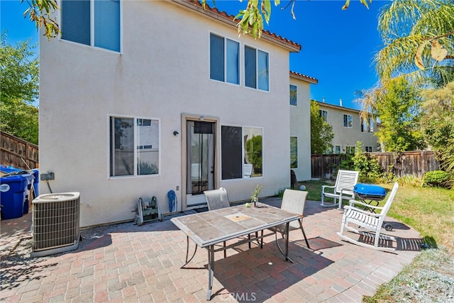 rear view of property with cooling unit, a patio area, fence, and stucco siding
