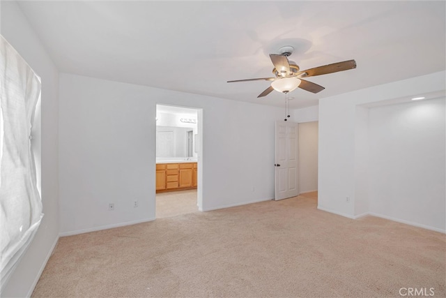 spare room with light carpet, baseboards, and a ceiling fan
