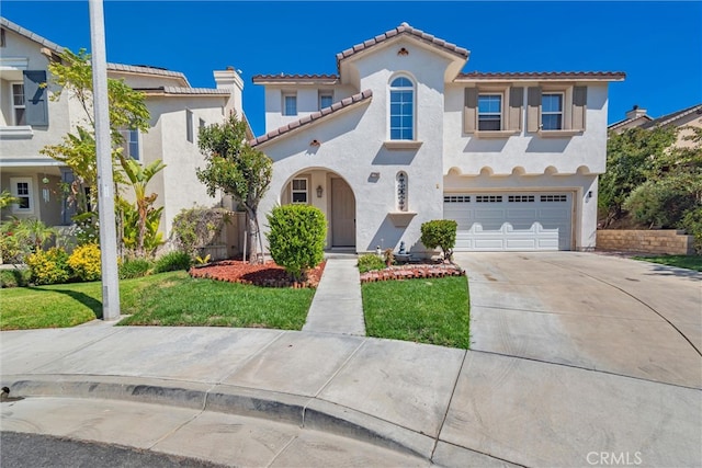 mediterranean / spanish-style home with stucco siding, driveway, a front yard, a garage, and a tiled roof