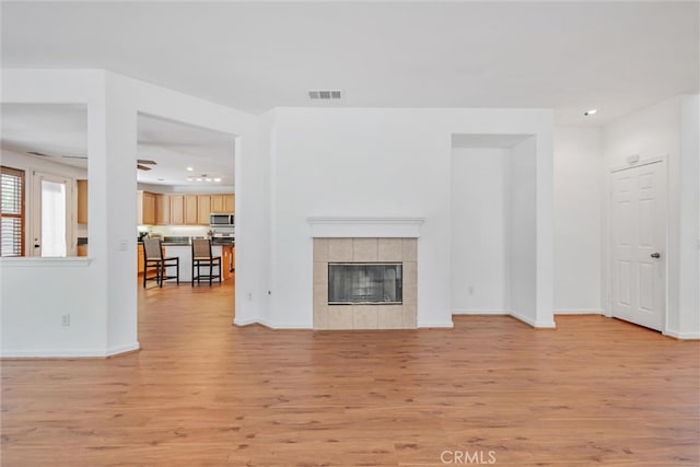unfurnished living room with visible vents, light wood-style flooring, recessed lighting, a fireplace, and baseboards