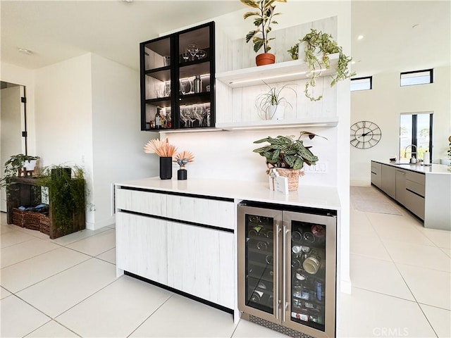 57601 Santo Thomas Ln, Quinta, CA 92253 - bar featuring baseboards, beverage cooler, a dry bar, light tile patterned floors, and a sink