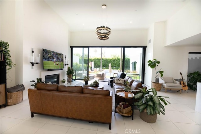 57601 Santo Thomas Ln, Quinta, CA 92253 - living room featuring light tile patterned flooring, a glass covered fireplace, and a high ceiling