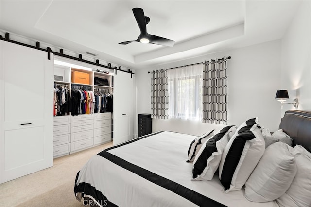 6 Via Presea, Coto De Caza, CA 92679 - carpeted bedroom featuring a raised ceiling, a barn door, a closet, and a ceiling fan