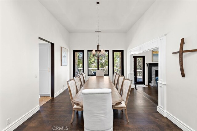 6 Via Presea, Coto De Caza, CA 92679 - dining area with a chandelier, dark wood-style floors, baseboards, a high ceiling, and a fireplace