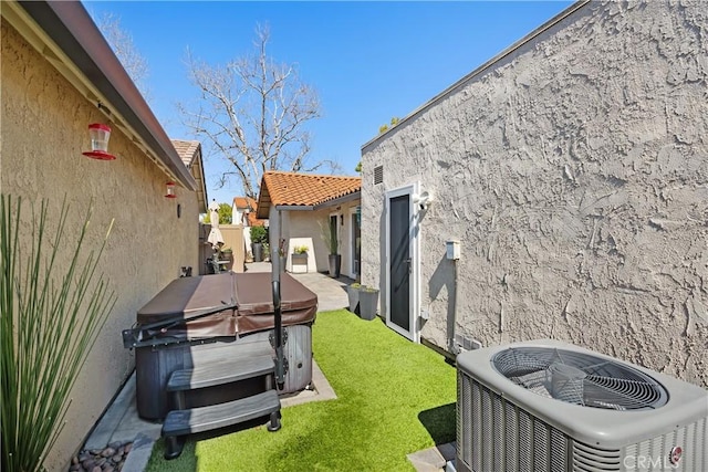 view of yard with a hot tub and central AC