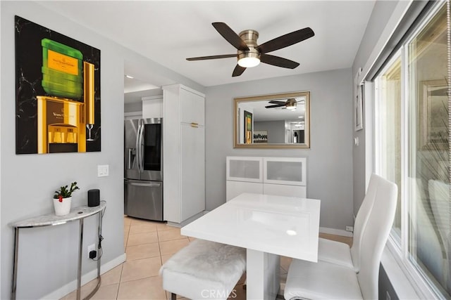 dining space featuring baseboards, ceiling fan, and light tile patterned floors