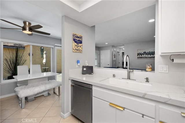 kitchen featuring white cabinetry, stainless steel dishwasher, light tile patterned floors, a sink, and ceiling fan