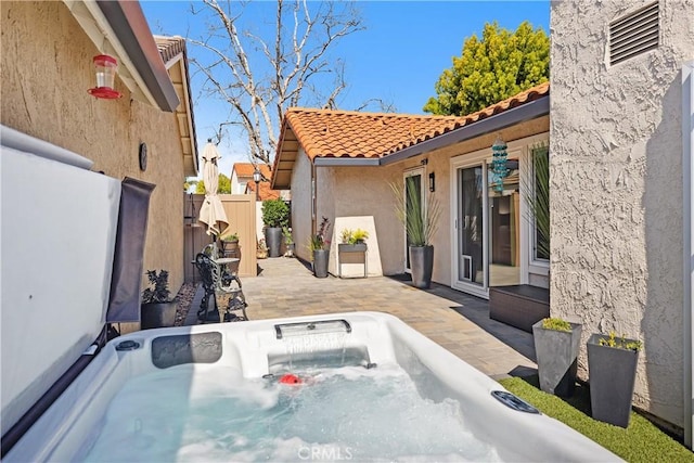 view of patio / terrace with fence and a hot tub